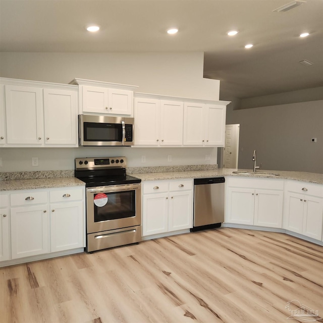 kitchen featuring white cabinetry, sink, stainless steel appliances, and light hardwood / wood-style flooring