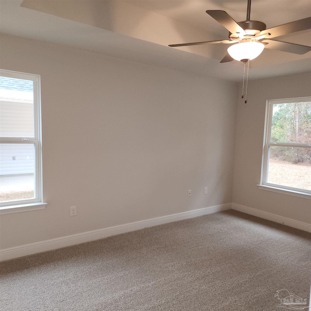 spare room with carpet flooring, a wealth of natural light, and ceiling fan