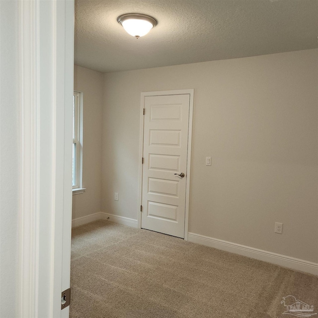 carpeted spare room featuring a textured ceiling