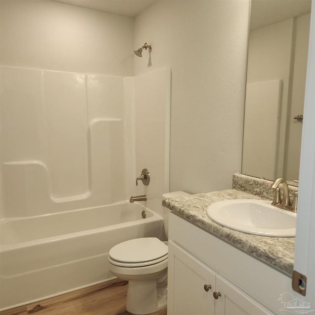 full bathroom with hardwood / wood-style floors, vanity, shower / bathtub combination, and toilet