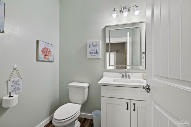 1621 E Cervantes St, Pensacola, FL 32501 - half bath featuring toilet, vanity, baseboards, and wood finished floors