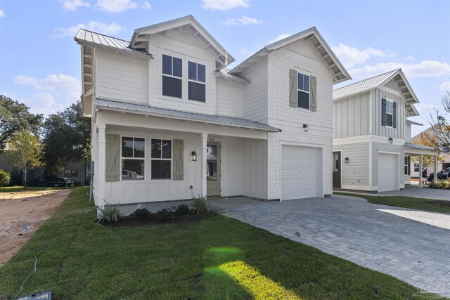 9616 Indian Stone Ct Lot 8, Navarre, FL 32566 - view of front facade featuring board and batten siding, an attached garage, a front yard, and metal roof