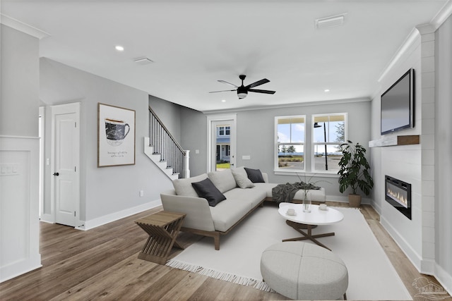 9616 Indian Stone Ct Lot 8, Navarre, FL 32566 - living room featuring visible vents, a glass covered fireplace, light wood-style floors, and ceiling fan