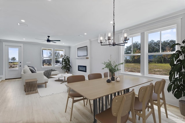 9616 Indian Stone Ct Lot 8, Navarre, FL 32566 - dining room with a glass covered fireplace, light wood-style flooring, ornamental molding, and ceiling fan with notable chandelier