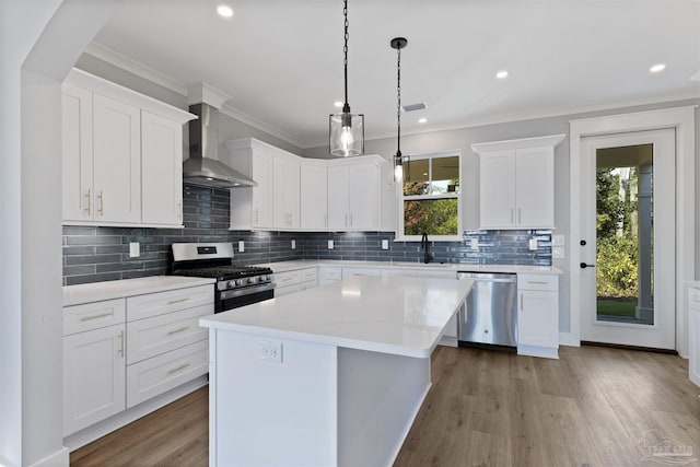 9616 Indian Stone Ct Lot 8, Navarre, FL 32566 - kitchen with stainless steel appliances, light countertops, wood finished floors, wall chimney exhaust hood, and a center island