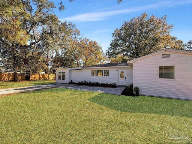 ranch-style home featuring fence and a front yard