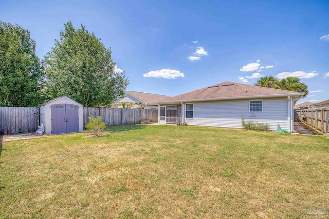 rear view of house with a sunroom, a storage shed, and a lawn