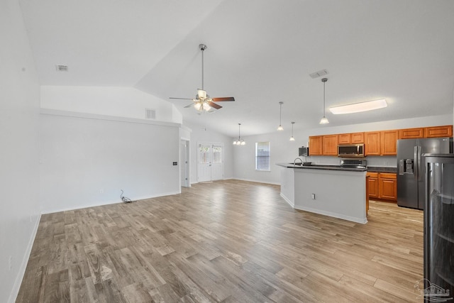 kitchen featuring ceiling fan, appliances with stainless steel finishes, lofted ceiling, and light hardwood / wood-style flooring