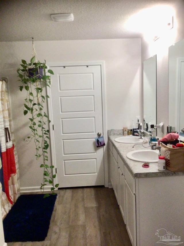 bathroom featuring hardwood / wood-style flooring, vanity, and a textured ceiling