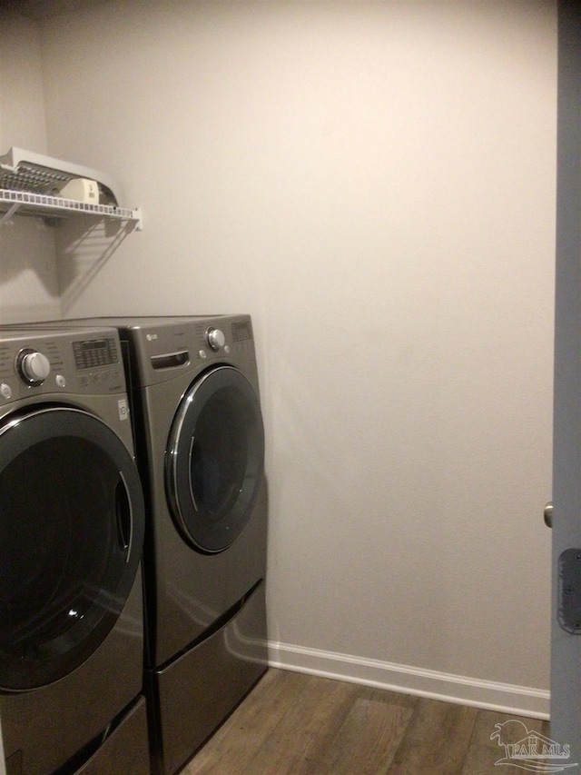 washroom with dark wood-type flooring and washing machine and dryer