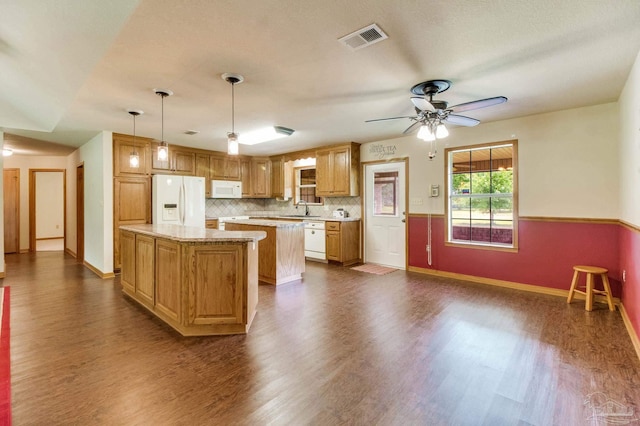 8206 Chumuckla Hwy, Pace, FL 32571 - kitchen with white appliances, a center island, a sink, light countertops, and dark wood-style floors