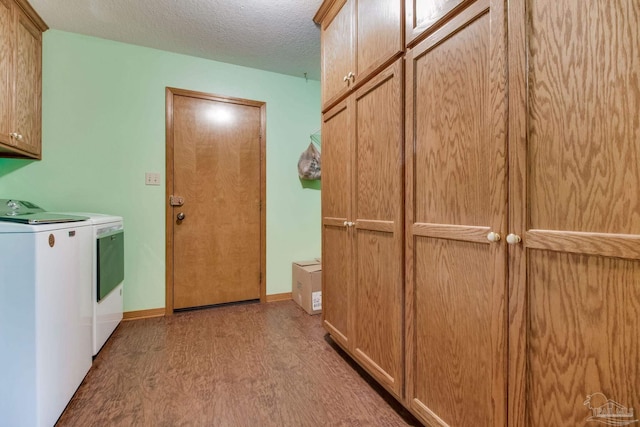 8206 Chumuckla Hwy, Pace, FL 32571 - laundry area with washing machine and clothes dryer, cabinet space, light wood-style flooring, and a textured ceiling