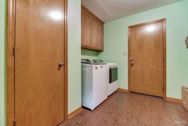 8206 Chumuckla Hwy, Pace, FL 32571 - laundry area with washer and clothes dryer, light wood-style floors, cabinet space, a textured ceiling, and baseboards