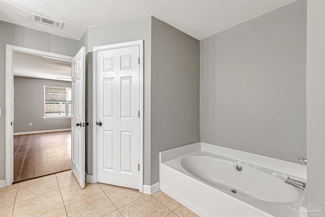 5773 Michael Dr, Milton, FL 32583 - bathroom featuring a textured ceiling, tile patterned floors, a bath, and baseboards