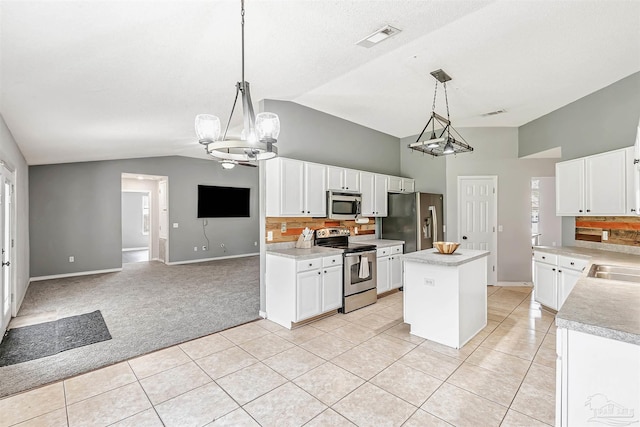5773 Michael Dr, Milton, FL 32583 - kitchen with appliances with stainless steel finishes, light tile patterned floors, light countertops, a center island, and baseboards
