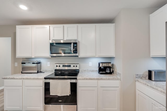 kitchen with white cabinets, stainless steel appliances, and recessed lighting