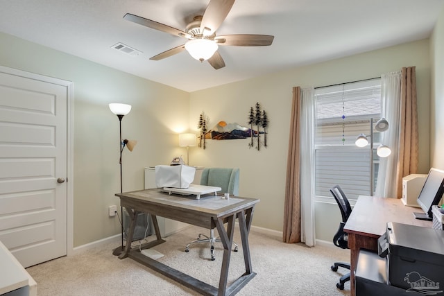 office space with light colored carpet, baseboards, a ceiling fan, and visible vents