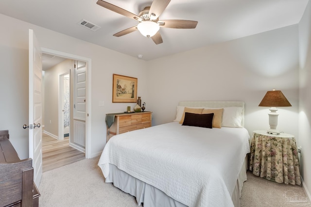 bedroom featuring light carpet, a ceiling fan, visible vents, and baseboards