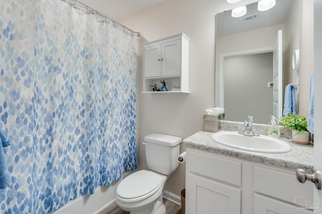 bathroom with wood finished floors, visible vents, vanity, and toilet