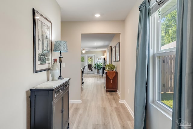 hall featuring baseboards, light wood-style floors, and recessed lighting