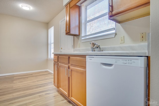 kitchen featuring dishwasher, a textured ceiling, light hardwood / wood-style flooring, and sink