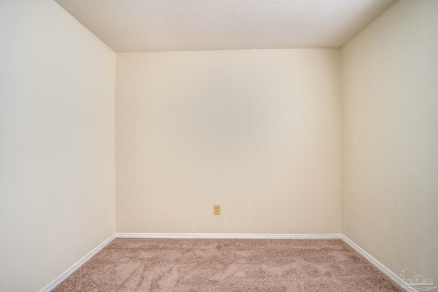 unfurnished room with light colored carpet and a textured ceiling