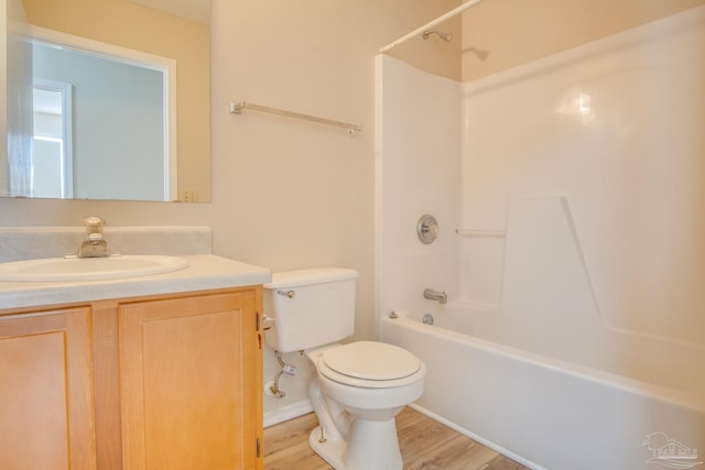 full bathroom featuring vanity, hardwood / wood-style floors, washtub / shower combination, and toilet