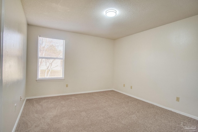 carpeted empty room with a textured ceiling