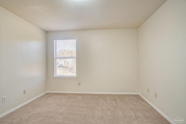 carpeted empty room featuring a textured ceiling