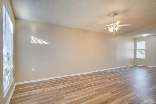 empty room with hardwood / wood-style floors, ceiling fan, and a textured ceiling