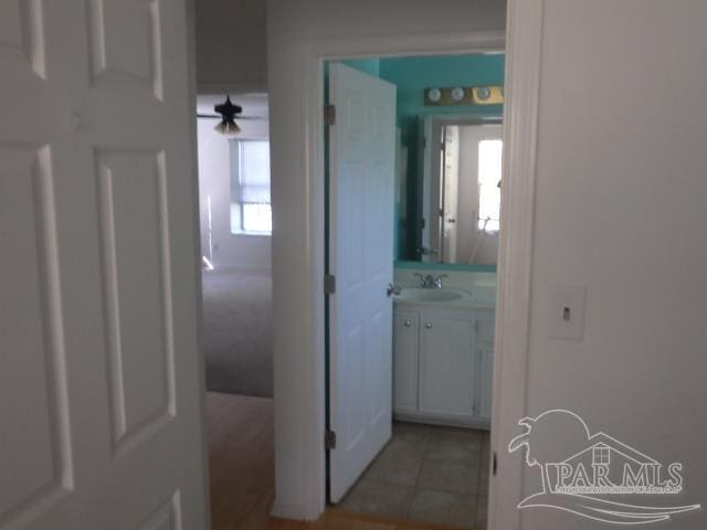 hall with sink and light tile patterned floors