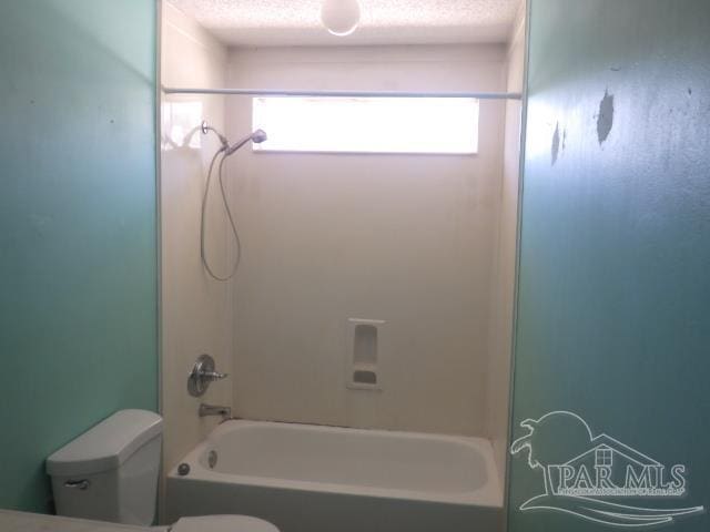 bathroom featuring a textured ceiling, shower / bathtub combination, and toilet