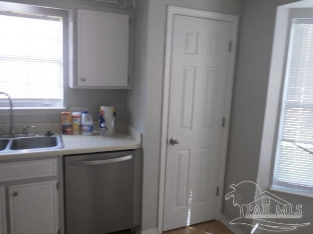 kitchen featuring dishwasher, sink, and white cabinets