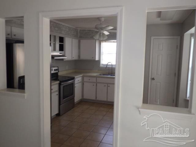 kitchen with appliances with stainless steel finishes, sink, white cabinets, ceiling fan, and tile patterned floors