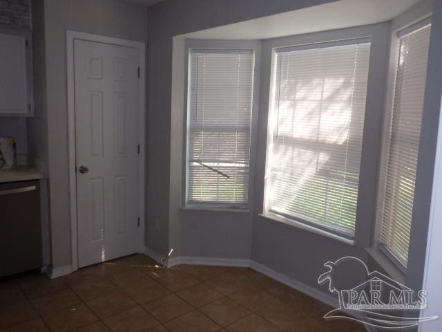 unfurnished dining area with dark tile patterned floors