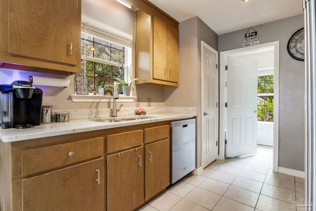 2661 Avenida De Sol, Navarre, FL 32566 - kitchen featuring stainless steel dishwasher, light tile patterned flooring, and brown cabinets