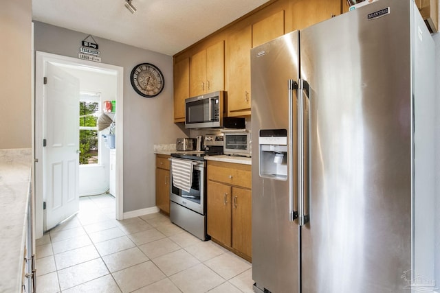 2661 Avenida De Sol, Navarre, FL 32566 - kitchen with stainless steel appliances, light countertops, light tile patterned floors, and brown cabinets