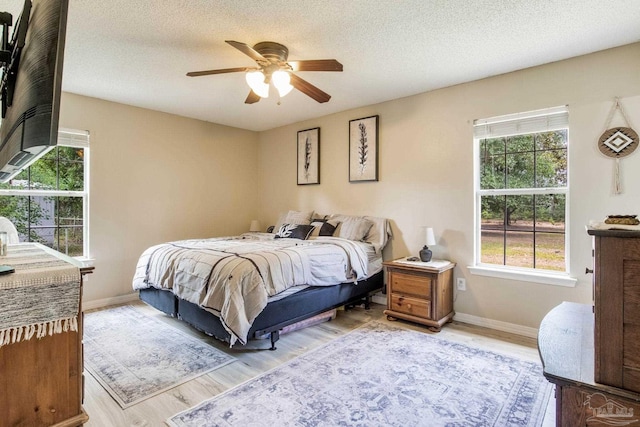 2661 Avenida De Sol, Navarre, FL 32566 - bedroom featuring light wood-style floors, a textured ceiling, and a ceiling fan