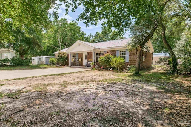 2661 Avenida De Sol, Navarre, FL 32566 - ranch-style home featuring brick siding, a storage unit, and driveway