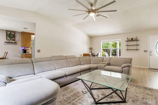 2661 Avenida De Sol, Navarre, FL 32566 - living room featuring light wood finished floors, vaulted ceiling, ceiling fan, and a textured ceiling