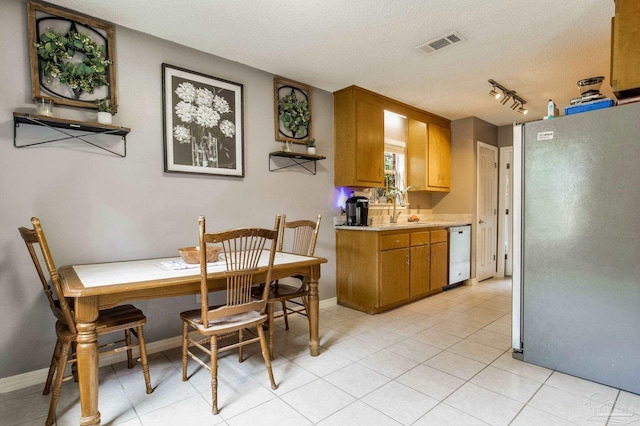 2661 Avenida De Sol, Navarre, FL 32566 - dining space with a textured ceiling, light tile patterned flooring, and rail lighting