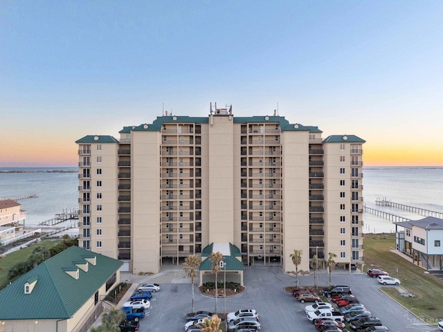 view of property featuring uncovered parking and a water view