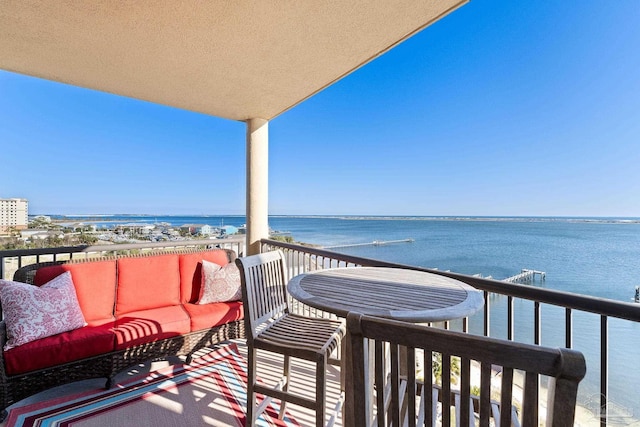 balcony featuring a water view and an outdoor living space