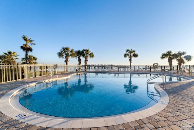 pool with a patio area and fence