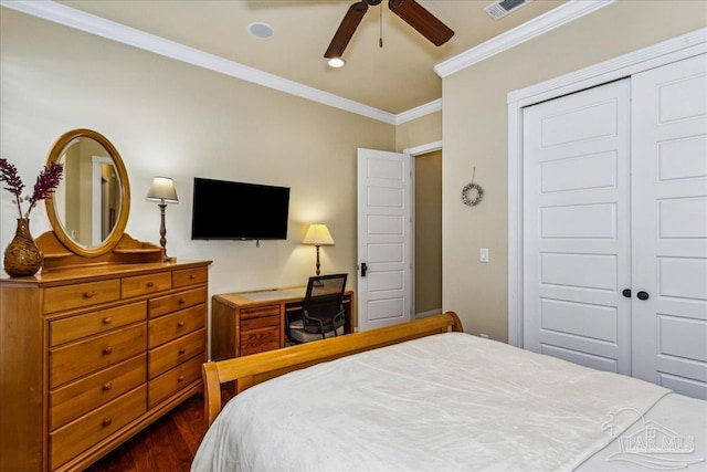 bedroom featuring dark wood finished floors, crown molding, a closet, visible vents, and a ceiling fan