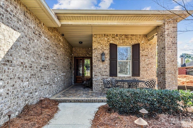 entrance to property featuring brick siding