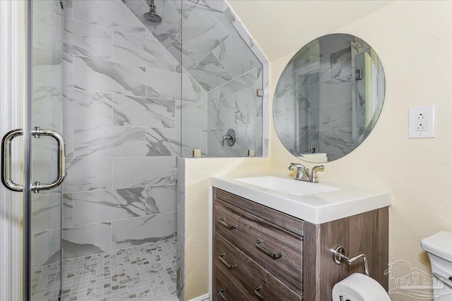 bathroom featuring vanity, a shower stall, and toilet