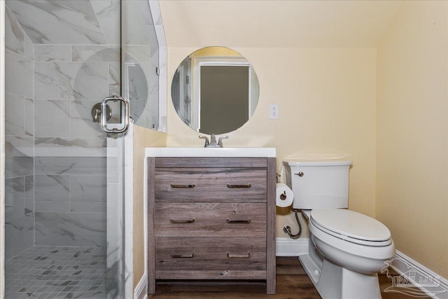 full bath featuring a stall shower, baseboards, toilet, wood finished floors, and vanity