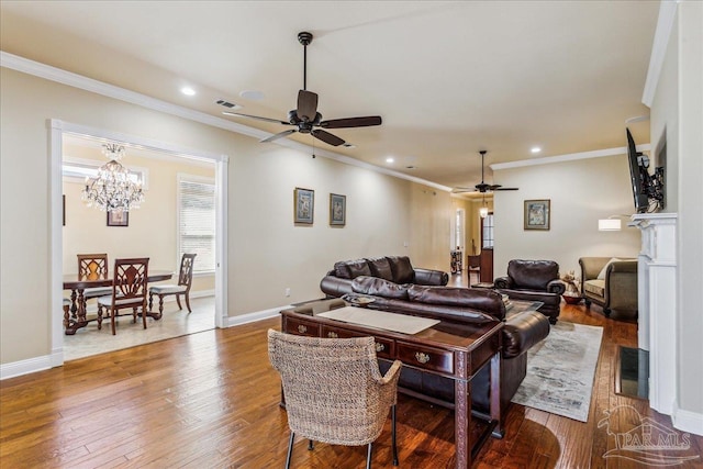 living area with hardwood / wood-style flooring, baseboards, visible vents, and ornamental molding