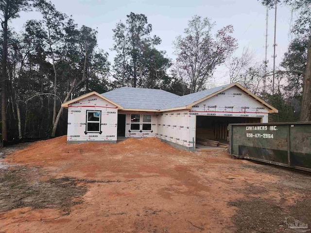 unfinished property featuring a garage and driveway